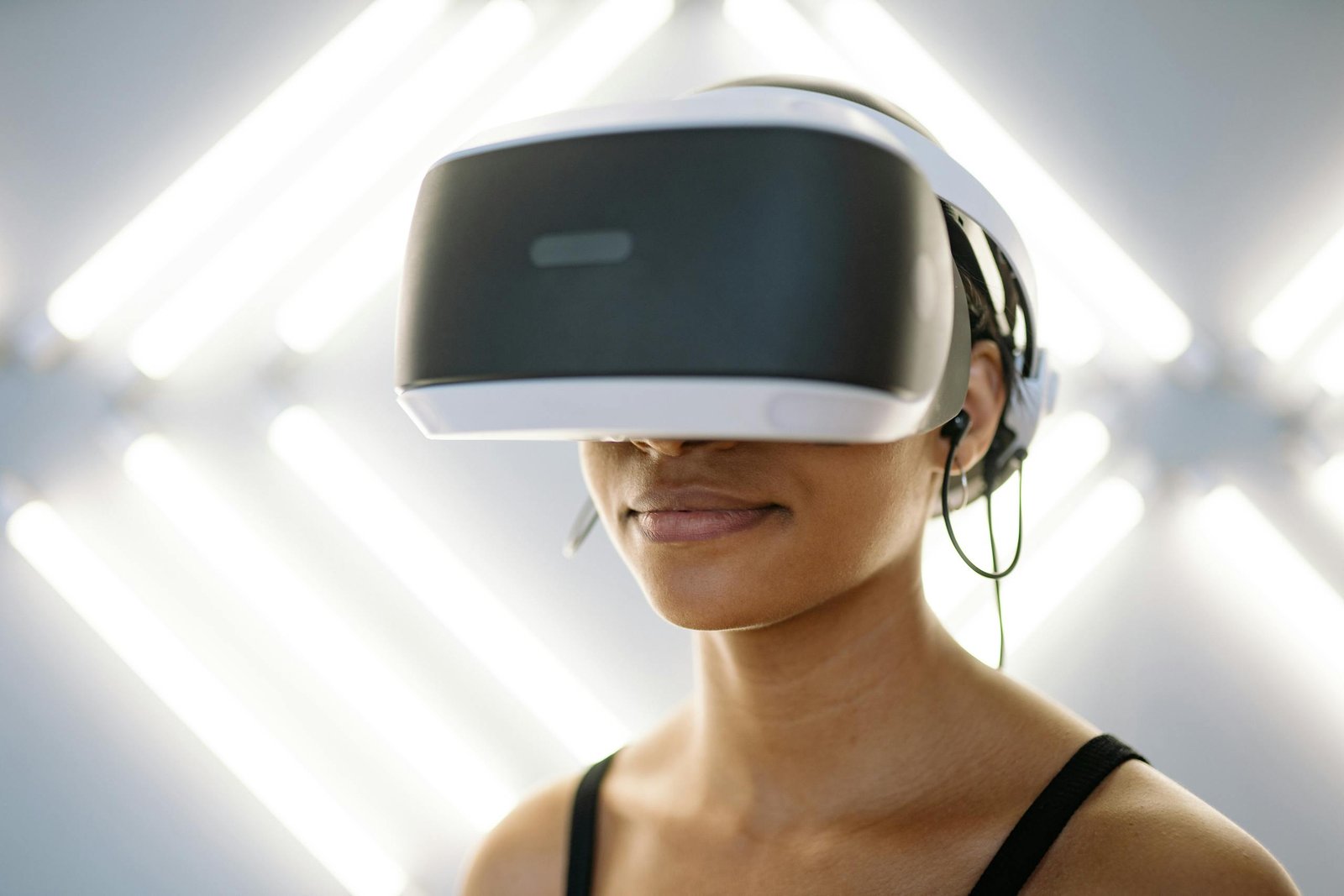 Close-up of a young woman wearing VR goggles, immersed in gaming indoors.